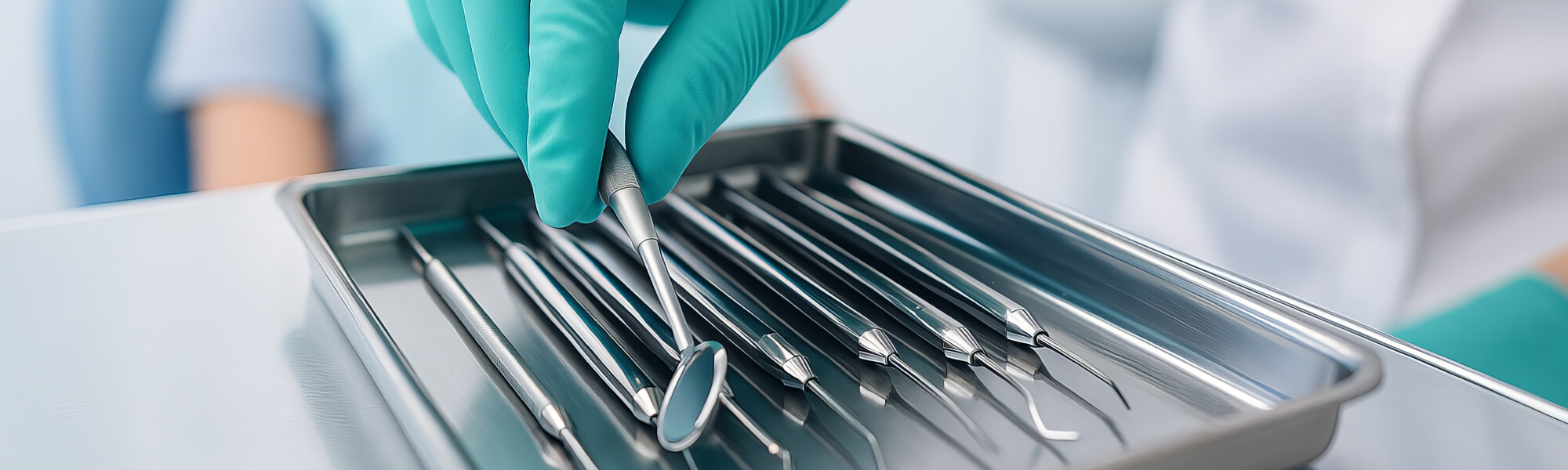 Zahnarzt mit Handschuhen greift in eine sterile Instrumentenschale mit zahnärztlichen Werkzeugen, im Hintergrund sitzt eine Patientin im Behandlungsstuhl.