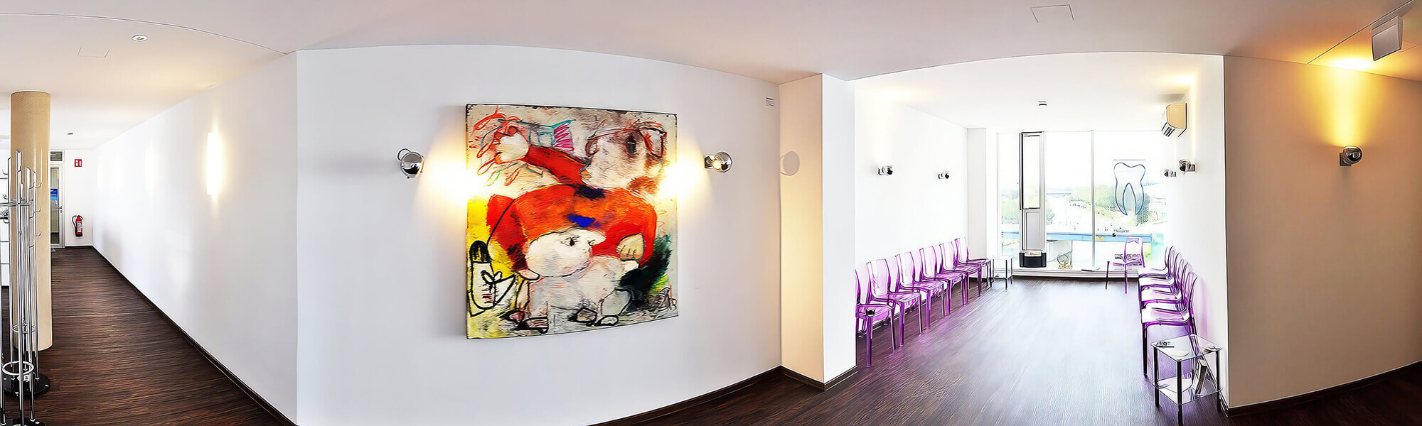 Breiter Praxisflur mit dunklem Boden, weißen Wänden, mehreren Wandlampen und einem bunten Wandbild; rechts angrenzender heller Wartebereich mit transparenten Stühlen