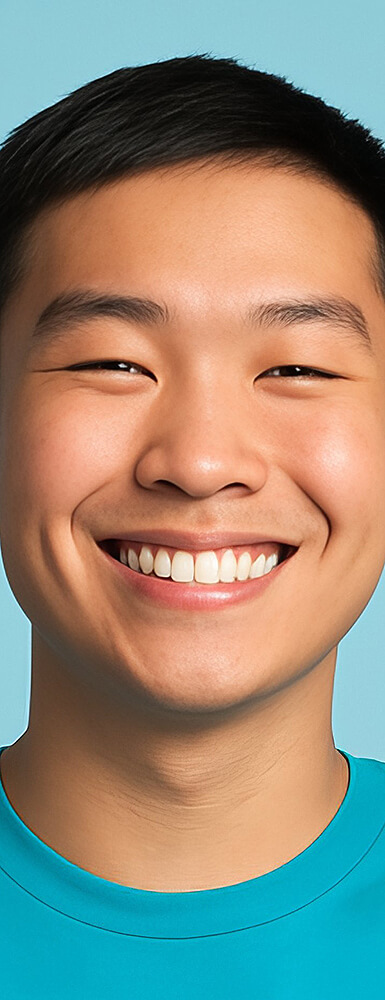 Lächelnder junger Mann mit kurzem dunklem Haar, blauer Hintergrund.